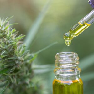 Marijuana leaf next to cbd distillate