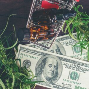 CBD bottles in a small shopping cart with 100 dollar bills