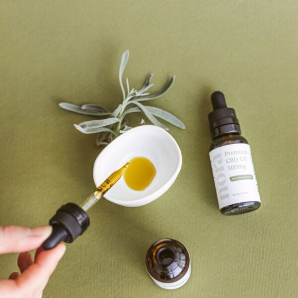 someone dripping a CBD tincture into a bowl